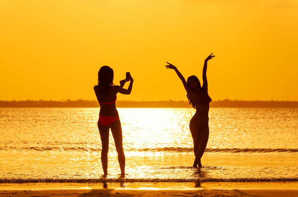 Silhouette Multi Ethnic Girls Swimwear Taking Photos Tropical Ocean Sunrise Stock Image