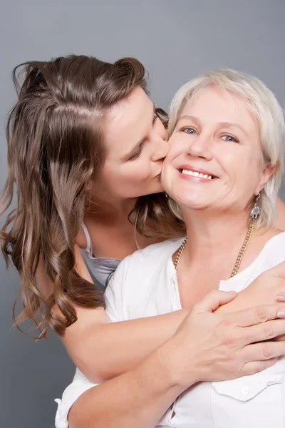 Playful Daughter kisses her Beautiful Mother on the cheek — Stock Photo, Image