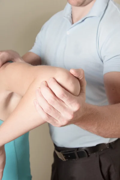 Chiropractor werken op jonge vrouwelijke patiënt elleboog — Stockfoto