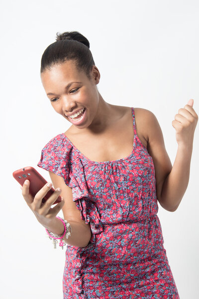 Young African woman excited over text message