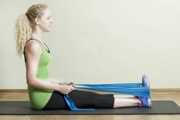 Kullanarak bir lastik bant egzersiz pilates eğitmeni — Stok fotoğraf