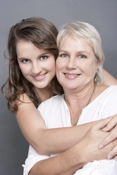 Hübsche Mutter und erwachsene Tochter umarmen sich in der Nähe — Stockfoto