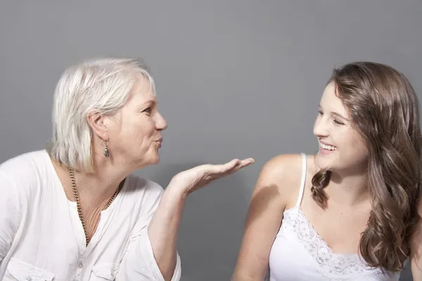 Mãe amorosa sopro beijos para filha crescida — Fotografia de Stock