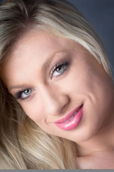 Крупный план молодой привлекательной блондинки, улыбающейся — стоковое фото