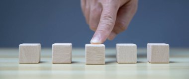 His hand touched the empty wooden cube. with text area and copy space