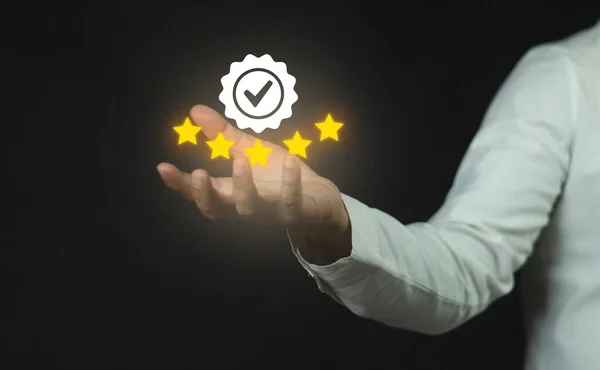 The customer's hand or the customer holds a star to complete five stars. with guarantee mark and copy space five star rating service rating Satisfaction Concept