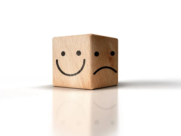 Parlak gülen yüzler ve beyaz arka planda tahta küplerdeki üzgün yüzler. Pozitif düşünmeyi seçme fikri için.