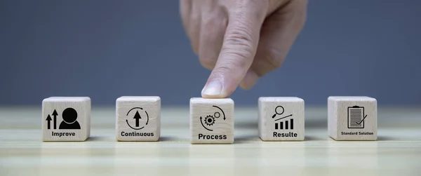 Kaizen concept; the continuous improvement in business for efficiency and effectiveness. Kaizen cycle icon on wood cubes; improve, continuous, process, result, standard solution. Quality improvement.
