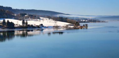 Saint Point lake in the Jura in winter in snowy weather. 