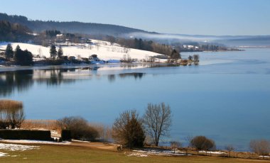 Saint Point lake in the Jura in winter in snowy weather. 