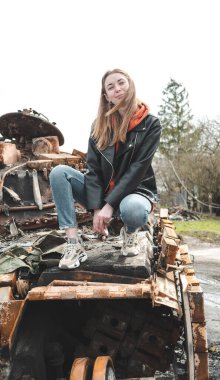 Ukrayna 'daki savaş, kızın imha edilmiş bir tankta fotoğrafı çekildi, Kyiv bölgesinde.