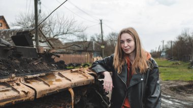 Ukrayna 'da savaş var. Kızın fotoğrafı imha edilen tankın yanında çekildi.