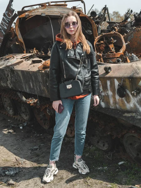 Ukrayna 'daki savaşta, kızın arka planında imha edilmiş Rus teçhizatı Kyiv bölgesi ile fotoğrafı çekildi.