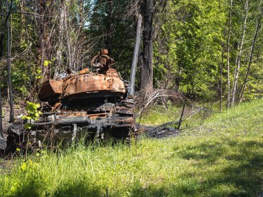 Ukrayna 'daki savaş, yıkılmış kulesi olan bir tank yol kenarında dikiz manzaralı bir ormanda duruyor.