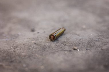 A cartridge case from an ak-47, a cartridge case from an assault rifle lies on the ground, close-up