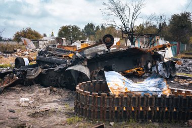 Ukrayna, parçalanmış bir Rus tankı, mühimmat patlaması, yıkılmış bir tank harabelerin arkasında duruyor. Izyum, Kharkiv bölgesi