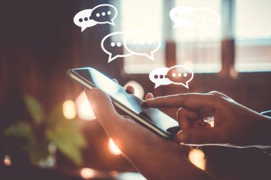 Sohbet ikonlarında akıllı telefon yazma, sohbet etme ya da kısa mesajlar kullanarak el ele tutuşuyorlar. Sosyal medya teknoloji kavramı. Klasik yumuşak renk tonu arkaplanı.