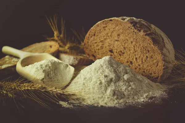 黒の背景にパン 小麦粉 小麦の小穂 小麦粉はベーキングの主な成分です — ストック写真