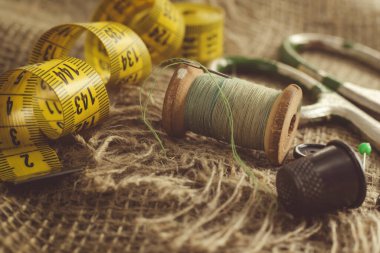Terzi, terzi, moda tasarımcısı işi için geçmişe dönük aletler. İplik, makas, yüksük, düğme ve santimetre ile iğne.