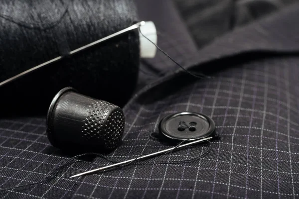 针和线缝上格子西服上的钮扣 Thimble 纺织品 — 图库照片