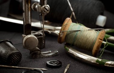 Eski dikiş makinesi, iplikli iğne, makas ve yüksük. Terzi, terzi ve elbise dikmek için moda tasarımcısı aletleri. El yapımı.