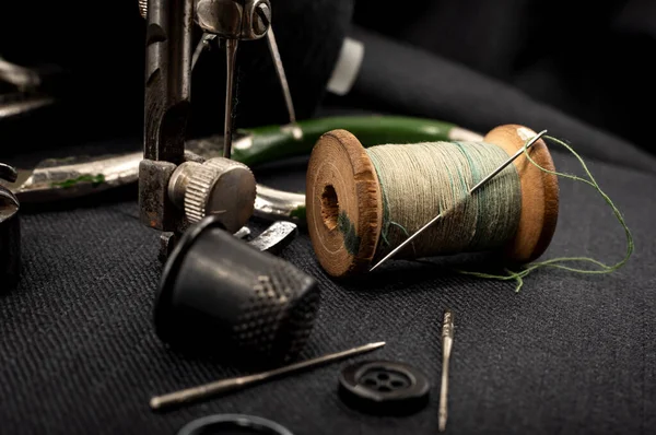 Eski dikiş makinesi, iplikli iğne, makas ve yüksük. Terzi, terzi ve elbise dikmek için moda tasarımcısı aletleri. El yapımı.