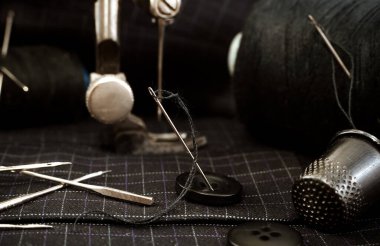 Eski dikiş makinesi, iplikli iğne, makas ve yüksük. Terzi, terzi ve elbise dikmek için moda tasarımcısı aletleri. El yapımı.