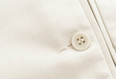 Button on white clothes. Element of men's clothing. Trousers