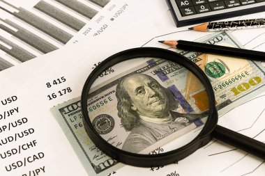 Dolarlar ve para yakın plan büyüteçle hesaplanıyor. Finans ve iş. Finansal hesap makinesi