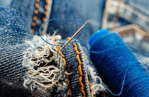 Kot pantolondaki delik. Örgü kotlar için iplikli iğne. Terzi, terzi, moda tasarımcısı için aletler