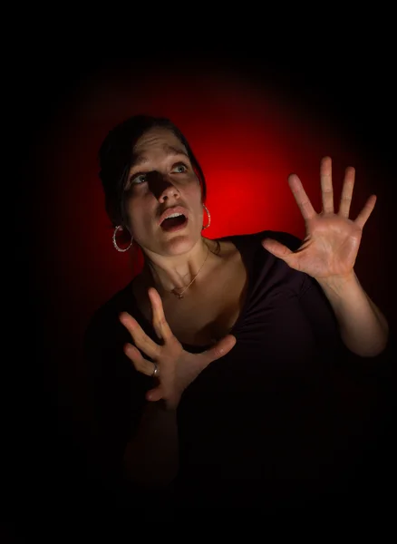 Scared woman on dark background — Stock Photo, Image