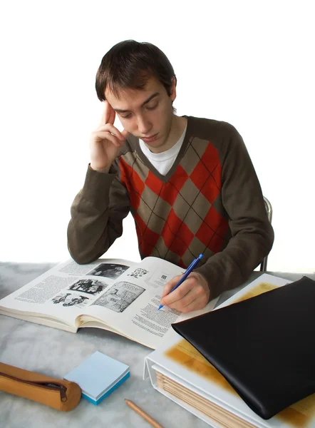 Male student at a table, holding head — Stock Photo, Image