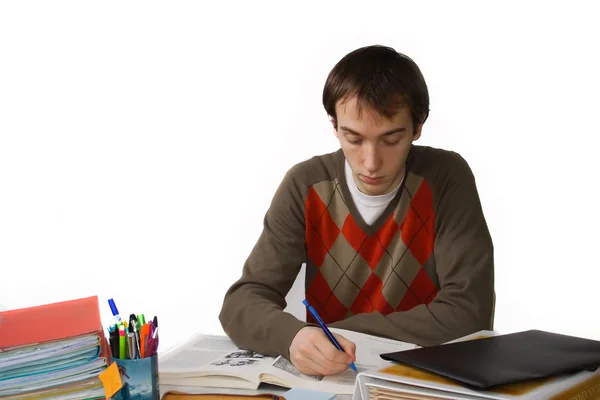 Studente maschio a un tavolo, scrive — Foto Stock