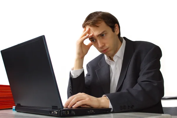 Closeup stressed Young man works on laptop — Stock Photo, Image