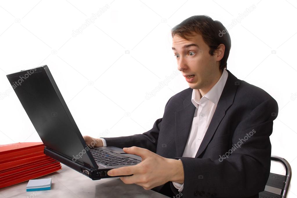 Young man freaks out in front of laptop