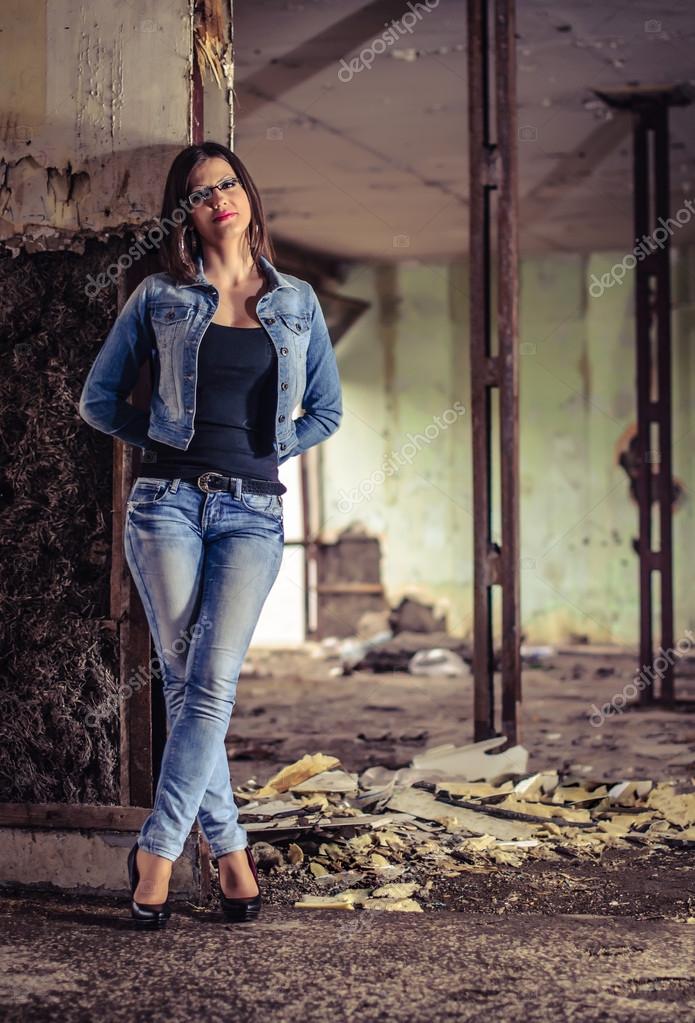 Gorgeous Brunette Girl with Long Flowing Hair Dressed in Jeans Jacket and Jeans  Poses Standing on the Dark Background in Stock Image - Image of denim,  emotions: 139573109