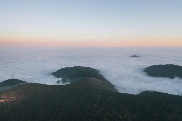 Ландшафт в горах на восходе солнца. Вид туманных холмов, покрытых лесом. Вид с воздуха. — стоковое фото
