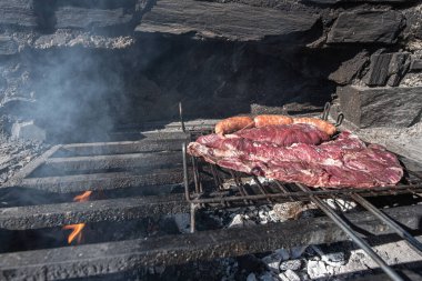 Tipik Uruguaylı ve Arjantinli Asado ateşte pişirilir. Entrana ve Vacio et kesimleri. Chorizo 'yla birlikte..