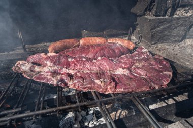 Tipik Uruguaylı ve Arjantinli Asado ateşte pişirilir. Entrana ve Vacio et kesimleri. Chorizo 'yla birlikte..