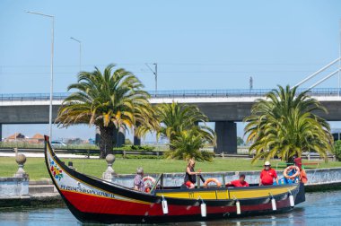 Aveiro, Portugal. 2022 May 12 . Traditional boats in the canal of Aveiro, Portugal. The colorful Moliceiro de Aveiro boat tours are popular with tourists to enjoy views of the charming canals. Aveiro, Portugal.