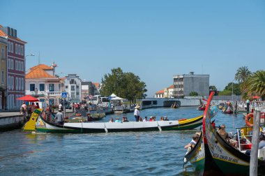 Aveiro, Portugal. 2022 May 12 . Traditional boats in the canal of Aveiro, Portugal. The colorful Moliceiro de Aveiro boat tours are popular with tourists to enjoy views of the charming canals. Aveiro, Portugal.