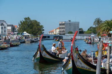 Aveiro, Portugal. 2022 May 12 . Traditional boats in the canal of Aveiro, Portugal. The colorful Moliceiro de Aveiro boat tours are popular with tourists to enjoy views of the charming canals. Aveiro, Portugal.