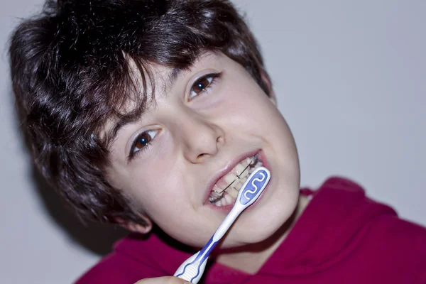 Feliz adolescente con aparatos ortopédicos y cepillarse los dientes —  Fotos de Stock