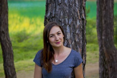 Güzel genç bir kadın kameraya gülümsüyor.