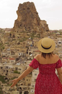 Kapadokya 'daki kaleye bakan şapkalı kadın, hindi