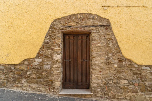 真ん中に扉のある部分的に漆喰の石の壁 — ストック写真