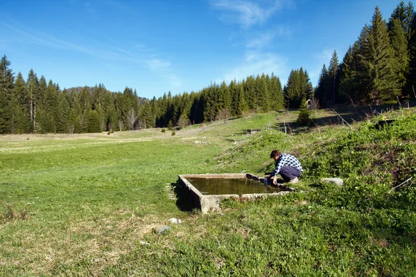 Ein junger Mann gießt Wasser — Stockfoto