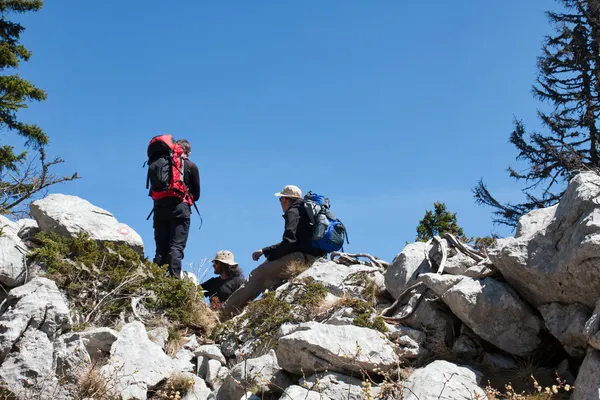 Trois alpinistes reposant sur le sommet de la colline — Photo