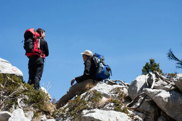 Dois montanhistas descansando no topo da colina — Fotografia de Stock