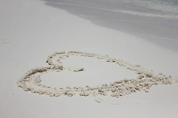 Heart in the sand beach. Heart drawn in the sand. Beach background.